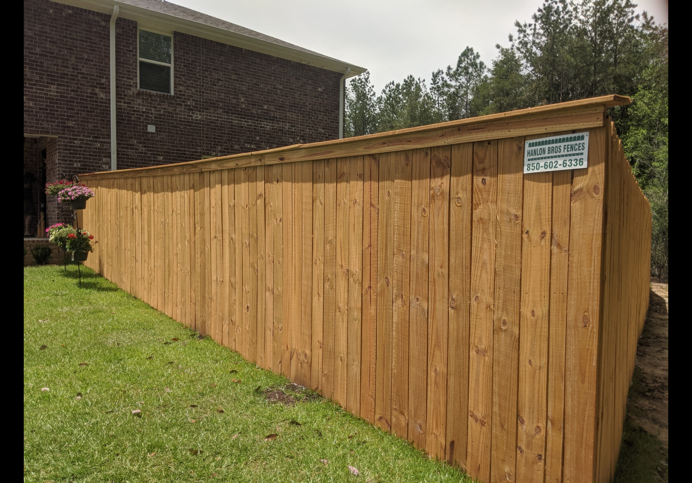 Cedar wood privacy fence with cap rail — completed project by Hanlon Brothers Fences, Milton FL